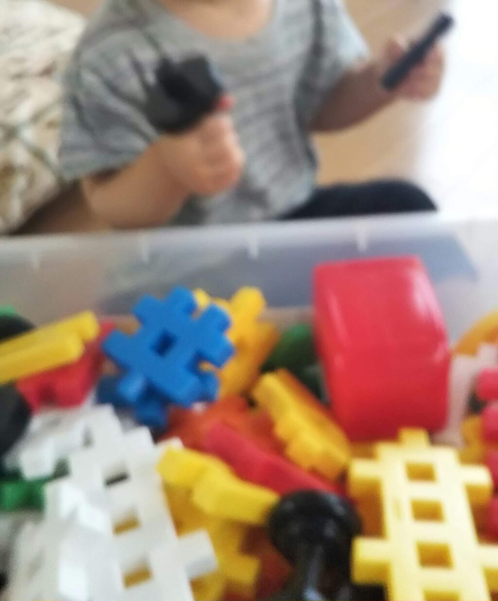 1歳3か月ごろ、床に広げたニューブロックに手を伸ばして遊ぶ様子