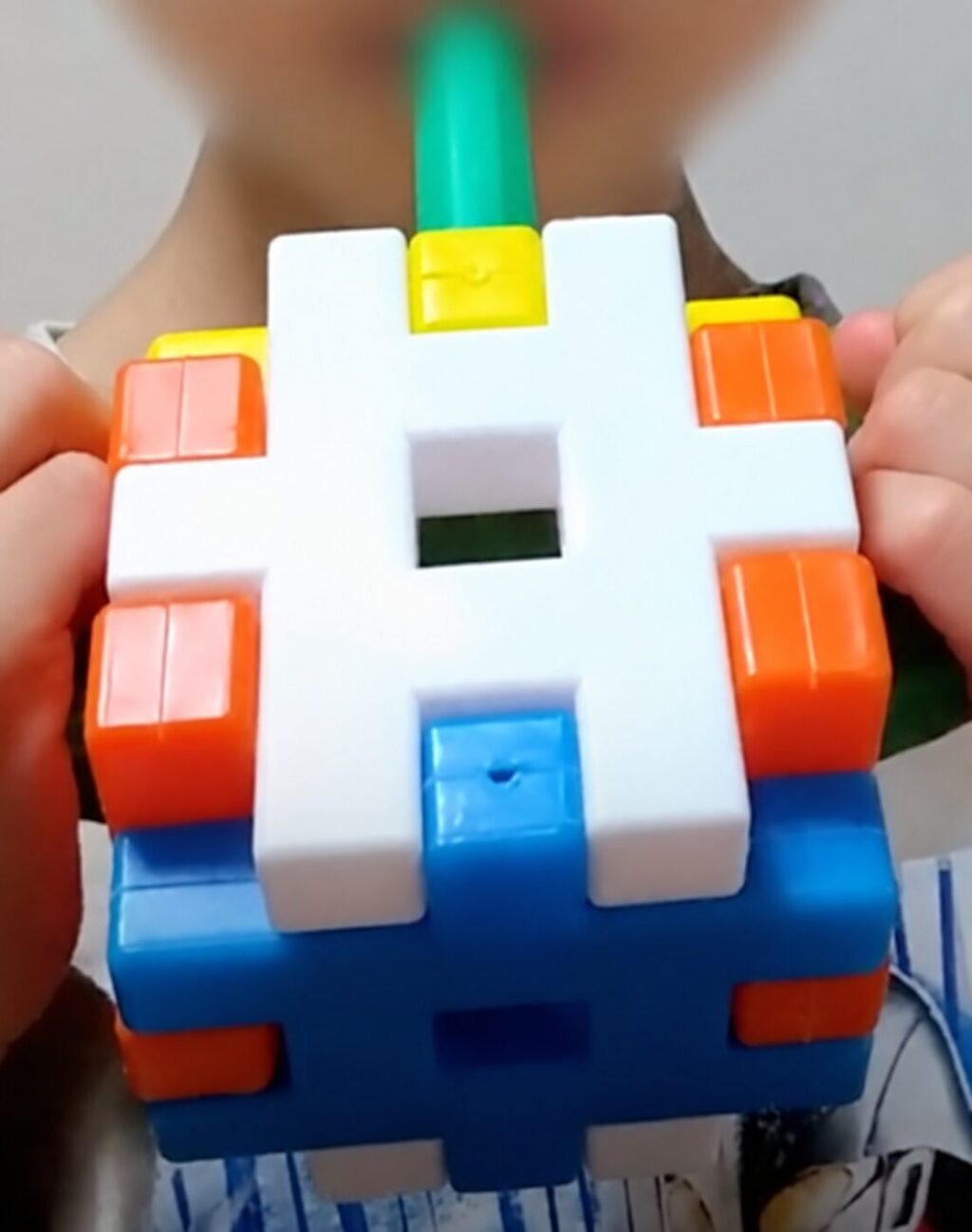4歳半ごろにニューブロックで作ったジュースの作品。背景の顔はぼかし加工済み